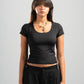 Woman wearing a black t-shirt and black pants on a gray background