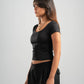 Woman wearing a black top and black pants on a light gray background