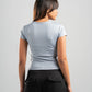 Woman wearing a gray t-shirt and black pants on a gray background