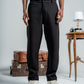 Person wearing black pants standing in a minimalistic setting with vintage suitcases and a table.