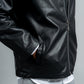 Black leather jacket worn by a person on a plain background