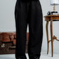 woman wearing a black pants against a neutral background