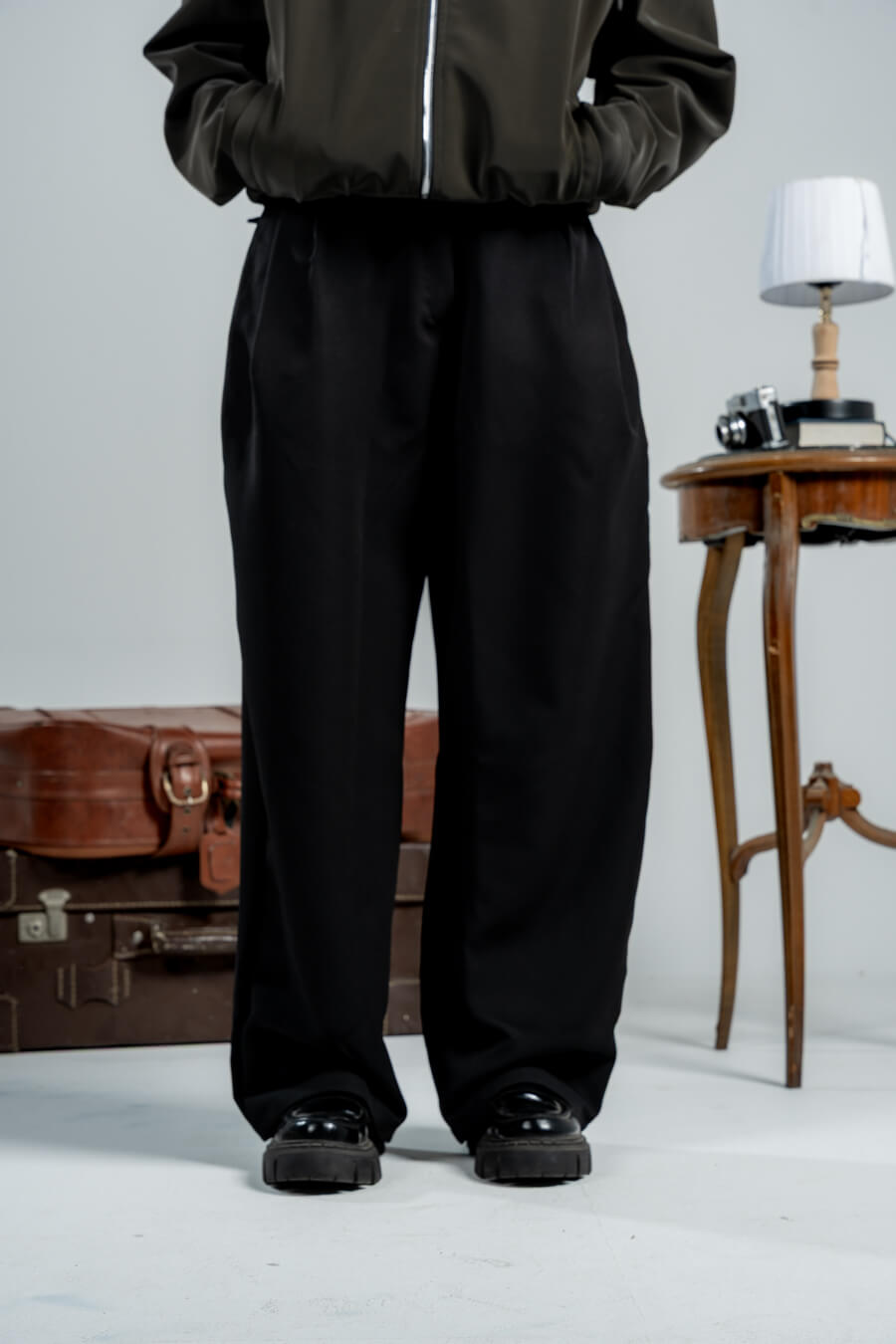 woman wearing a black pants against a neutral background