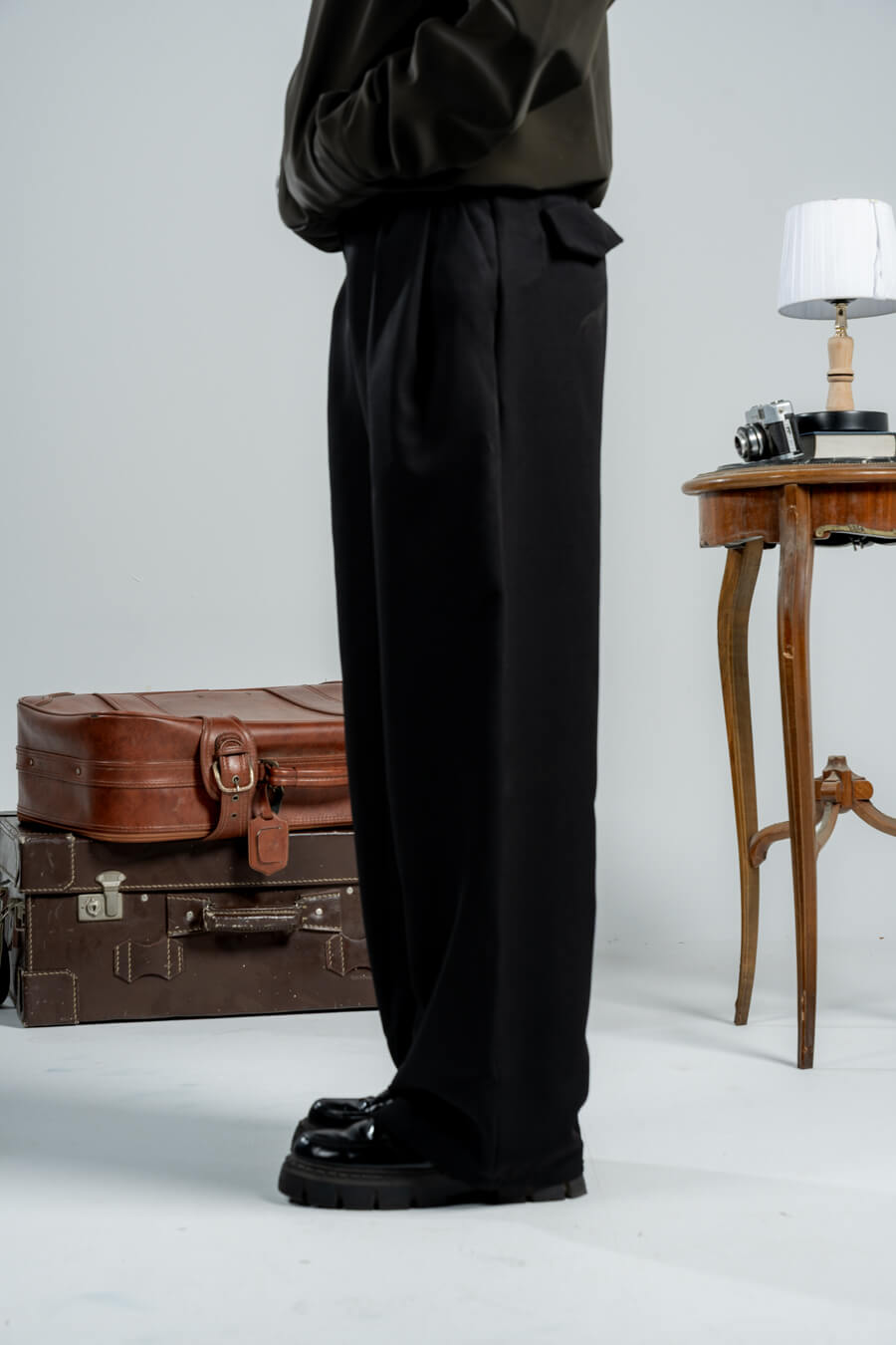 woman wearing a black pants against a neutral background