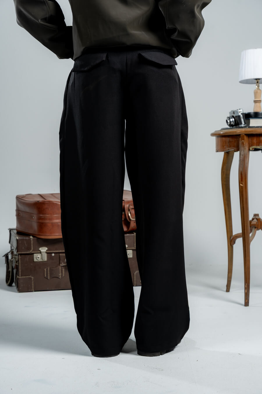 woman wearing a black pants against a neutral background