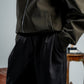 woman wearing a black pants against a neutral background