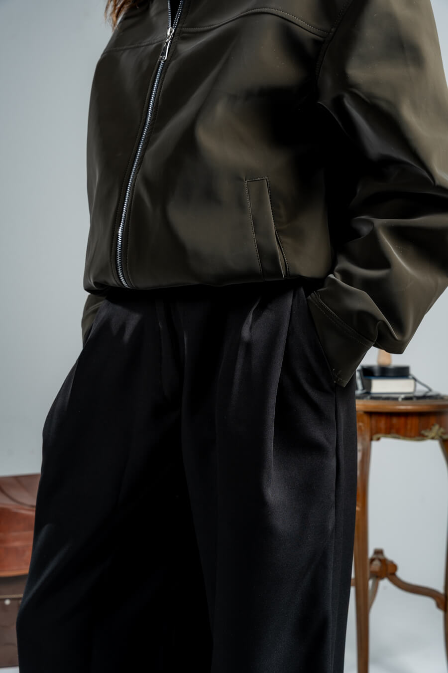 woman wearing a black pants against a neutral background