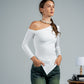 Woman wearing a white long-sleeve top and green pants against a plain background