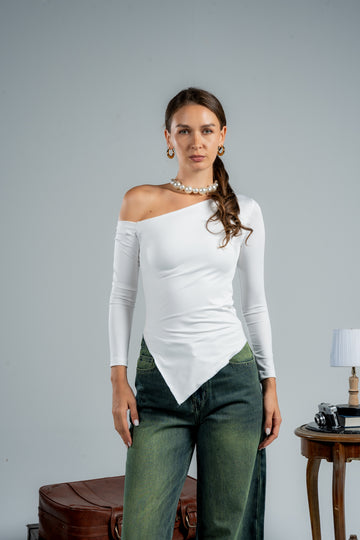 Woman wearing a white off-shoulder top and green pants against a gray background