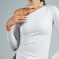Woman wearing a white long-sleeve top with a pearl necklace against a gray background