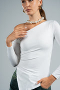 Woman wearing a white long-sleeve top with a pearl necklace against a gray background