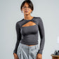 Woman wearing a gray long-sleeve top and light gray pants against a plain background