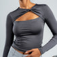 Woman wearing a gray long-sleeve top with a knot detail on a plain background