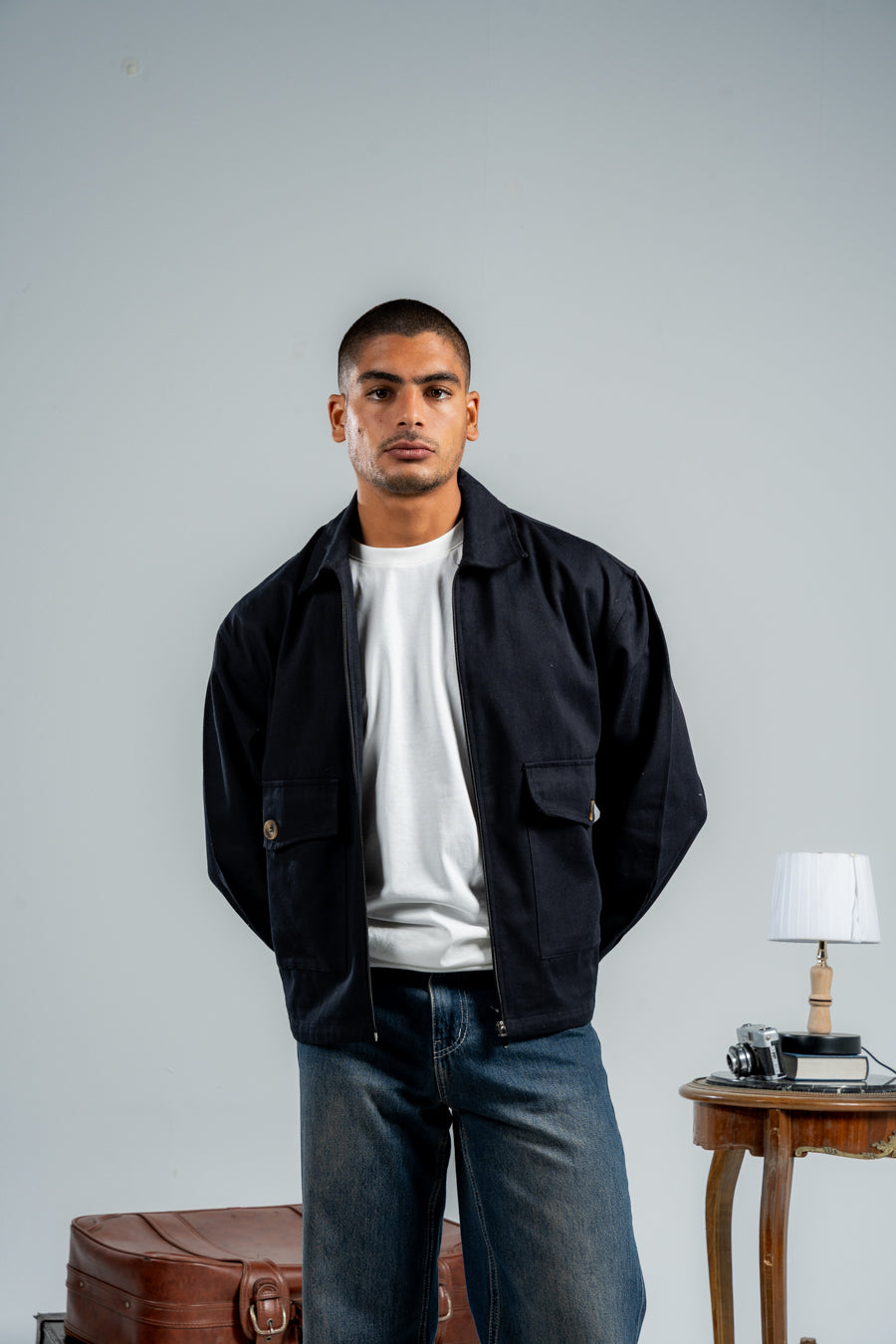 Man wearing a black jacket over a white shirt with a plain backgroundshop_this_look_TThFR4