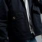 Person wearing a dark blue jacket with a blurred background