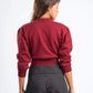 Person wearing a red sweater and black pinstripe pants on a white background