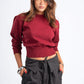 Woman wearing a red sweater and black pinstripe pants on a white background