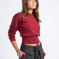 Woman wearing a red sweater and gray pinstripe pants on a white background