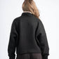 Person wearing a dark green sweater and brown pants on a white background