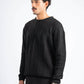 Man wearing a black sweater against a white background