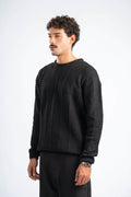 Man wearing a black sweater against a white background