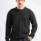 Man wearing a black cable knit sweater on a white background