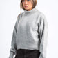Woman wearing a gray sweater on a white background