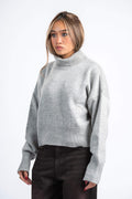 Woman wearing a gray sweater on a white background