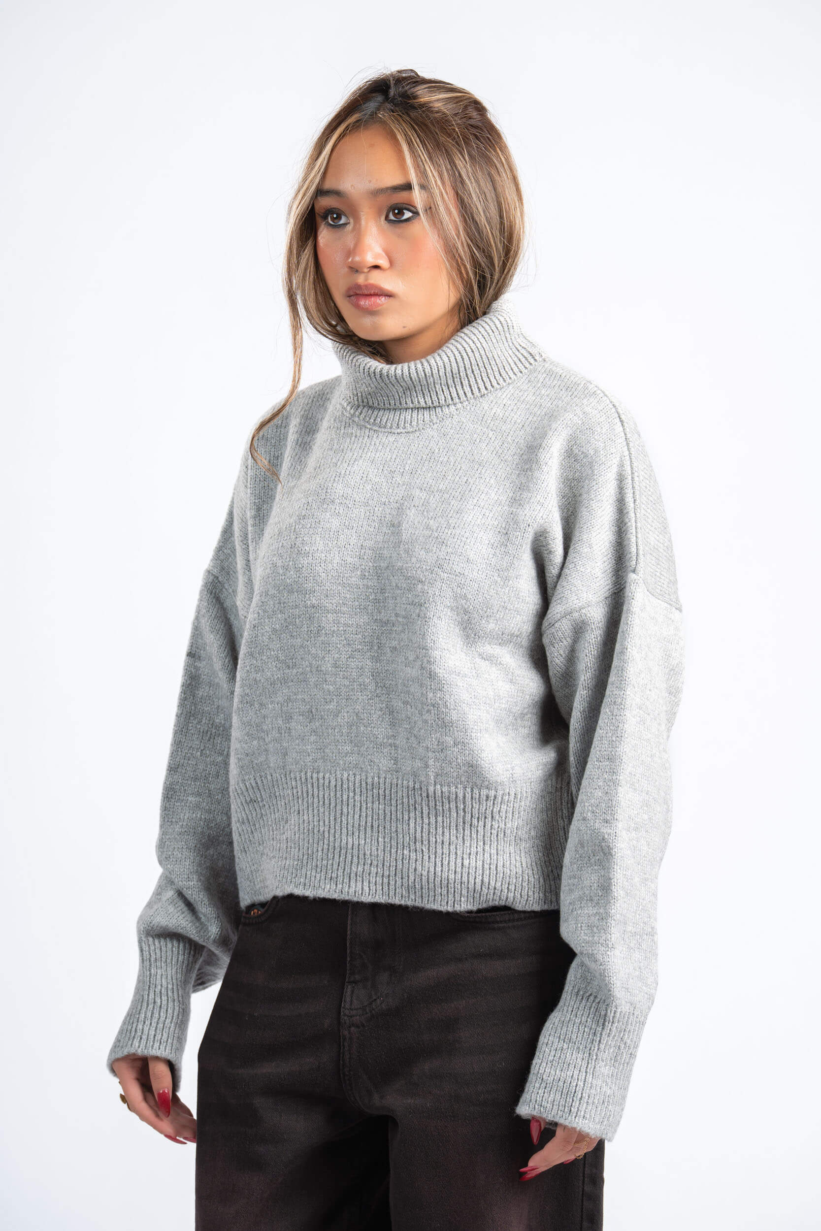 Woman wearing a gray sweater on a white background