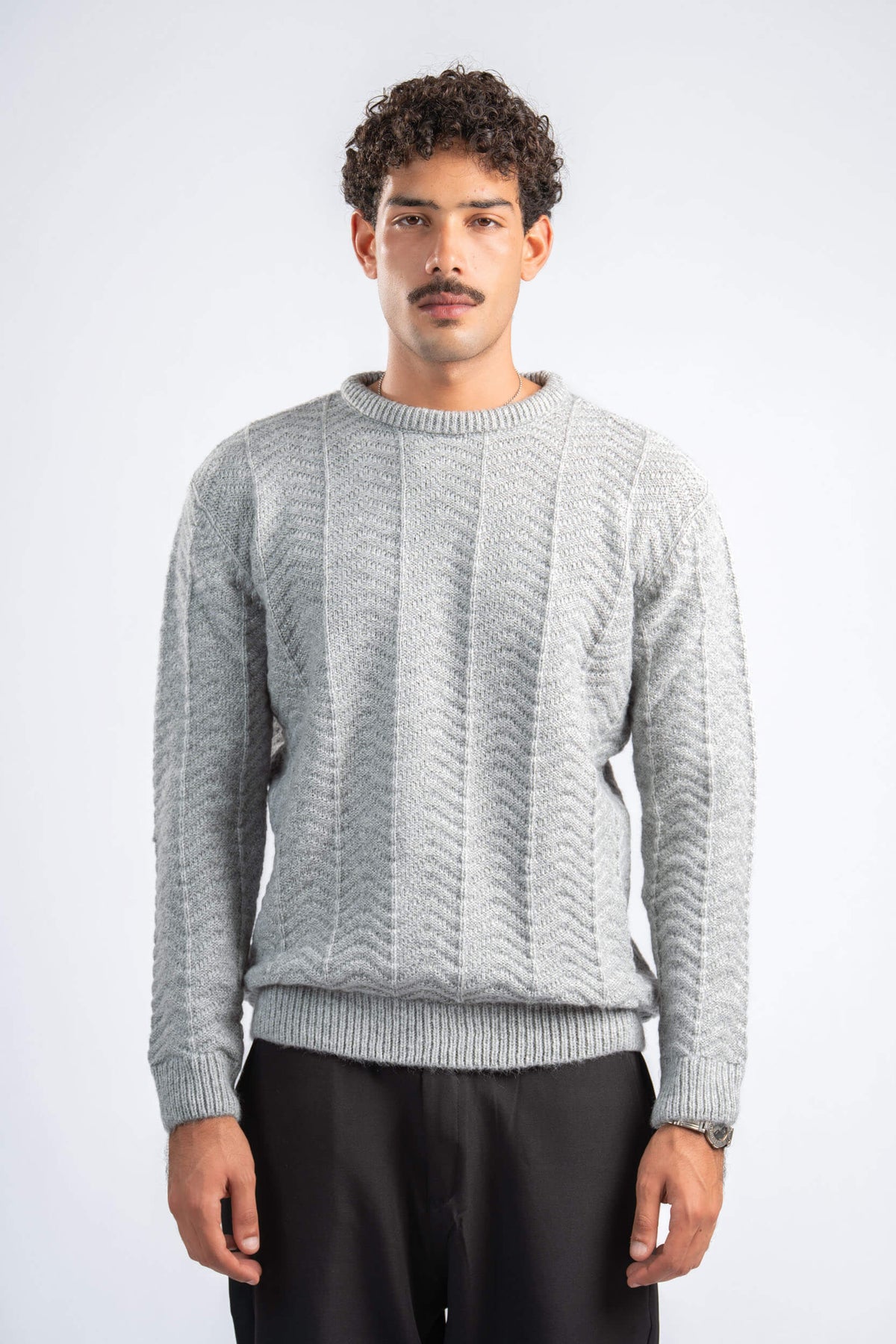 Man wearing a gray knitted sweater on a white background