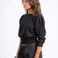 Woman wearing a black sweater and pinstripe pants on a white background