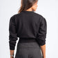 Person wearing a black sweater and pinstripe pants on a white background