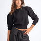 Woman wearing a black top and striped pants on a white background