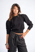 Woman wearing a black top and striped pants on a white background