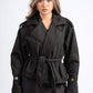 Woman wearing a black coat with a belt on a white background