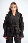 Woman wearing a black coat with a belt on a white background