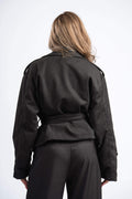 Person wearing a black jacket and pants on a white background