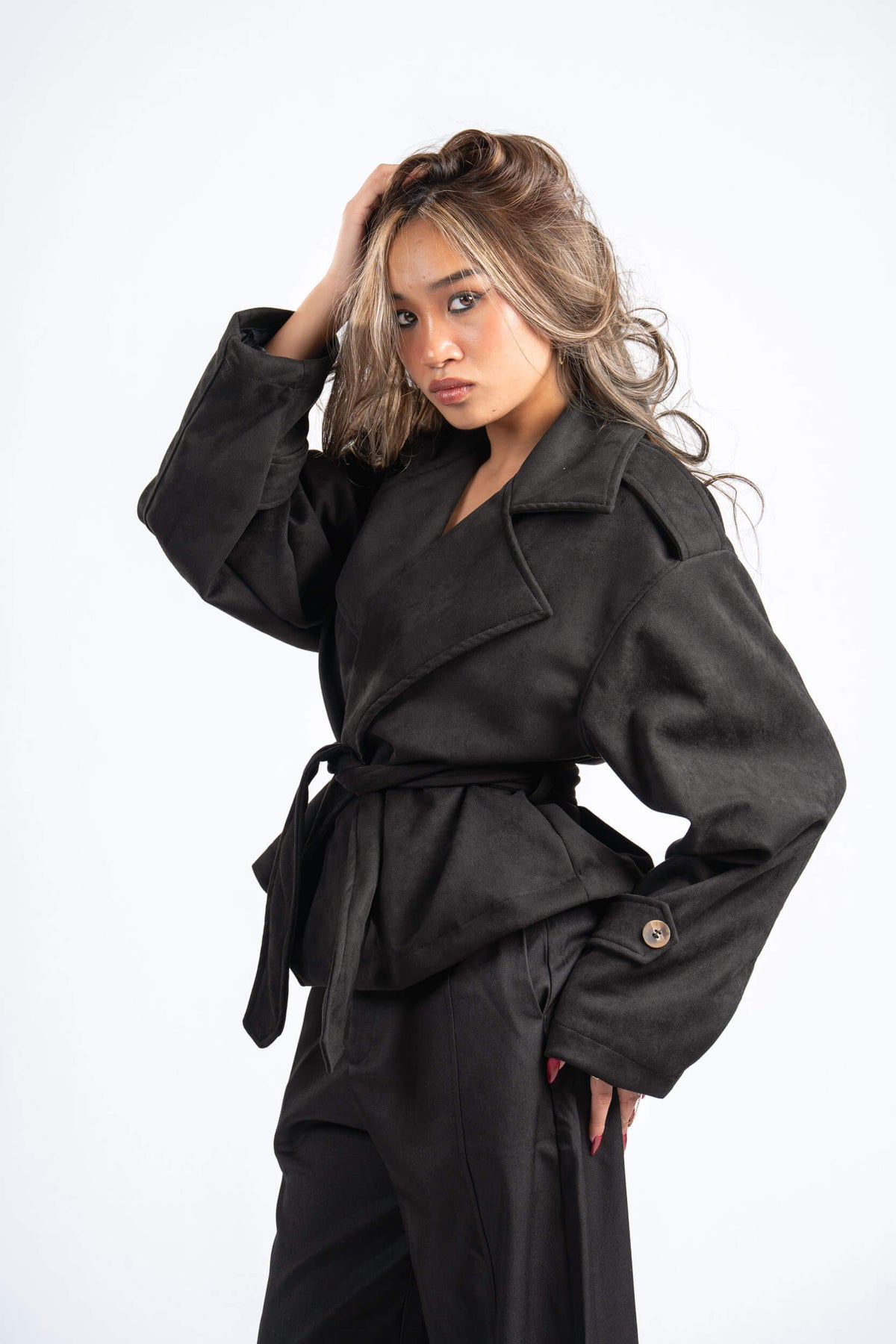 Woman wearing a black coat with a white background