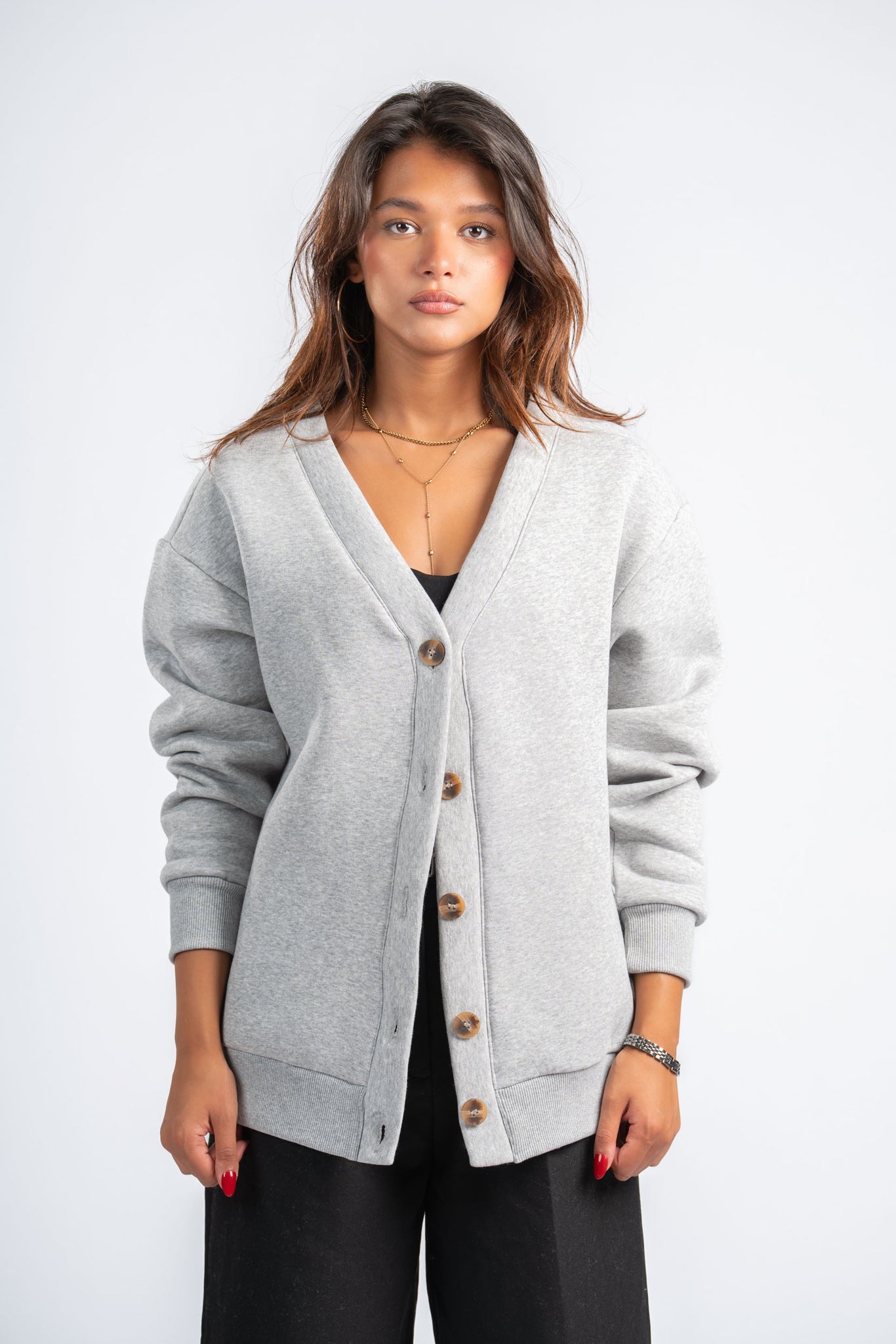 Woman wearing a gray cardigan on a white background