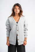Woman wearing a gray cardigan on a white background