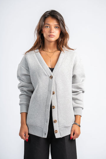 Woman wearing a gray cardigan on a white background