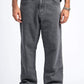 Person wearing gray jeans and black shoes on a white background