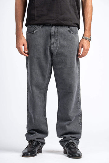 Person wearing gray jeans and black shoes on a white background