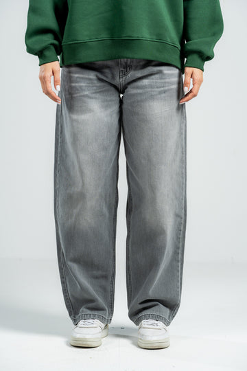 Person wearing a green sweatshirt and gray jeans on a white background