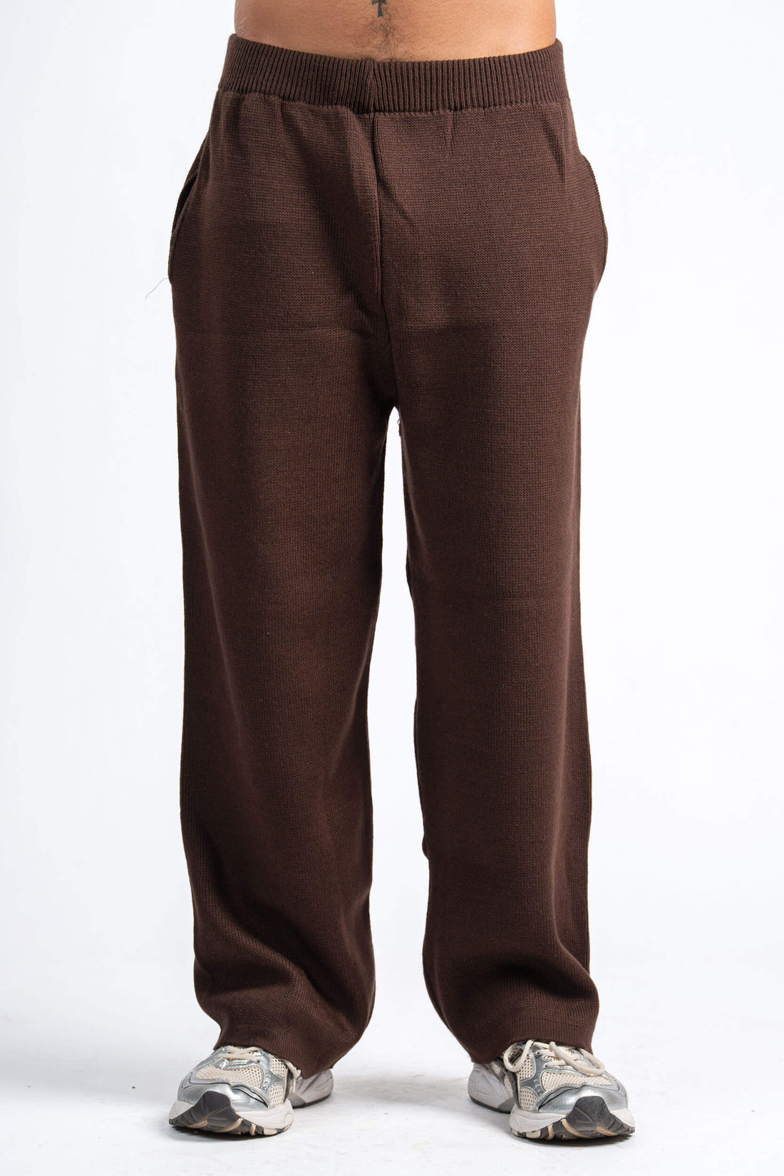 Two people wearing matching brown outfits on a white background