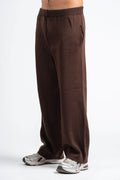 Brown sweatpants worn by a person on a white background