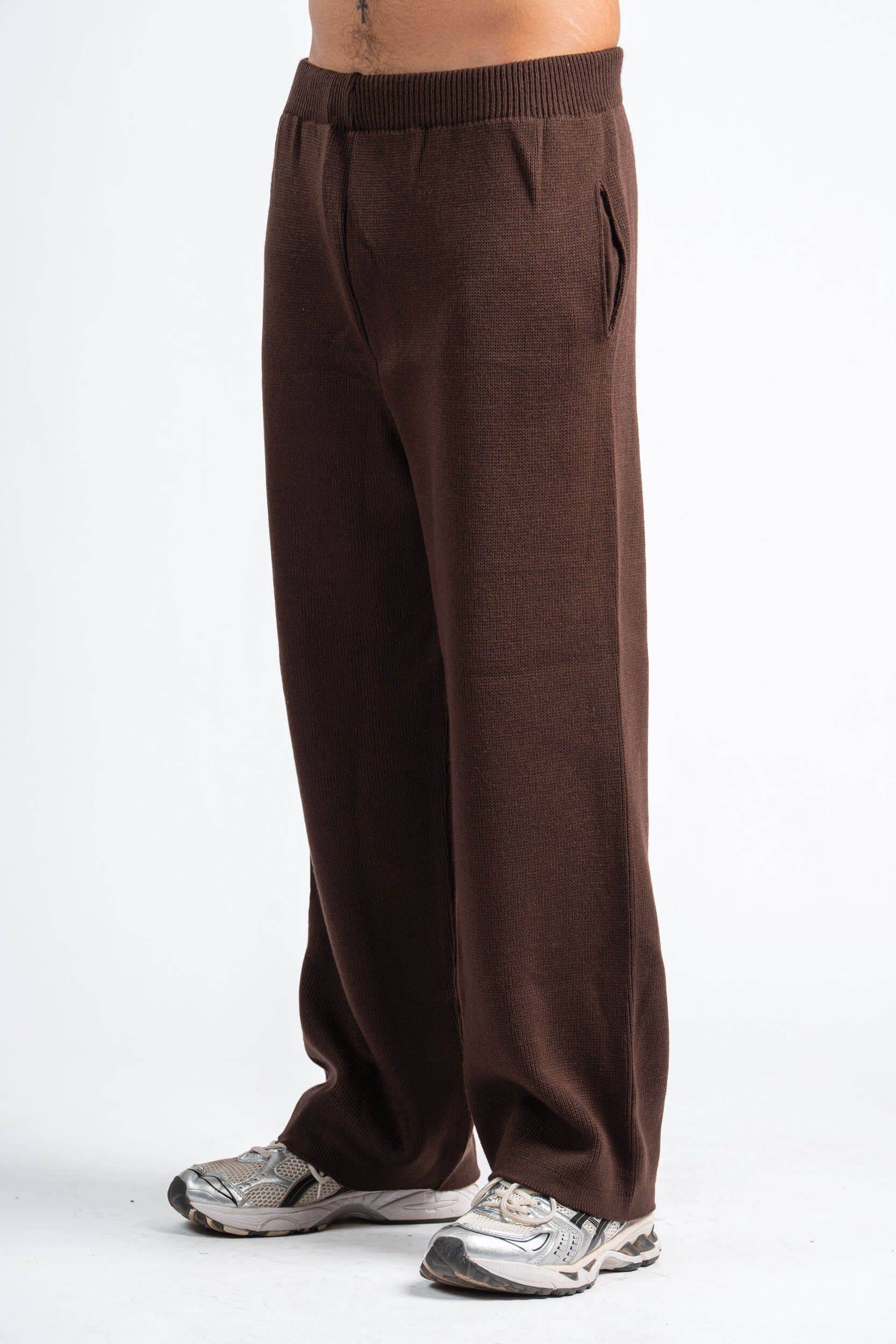 Brown sweatpants worn by a person on a white background