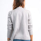 Person wearing a gray sweater and blue jeans on a white background