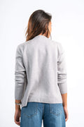 Person wearing a gray sweater and blue jeans on a white background
