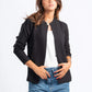 Woman wearing a black jacket, white shirt, and blue jeans on a white background